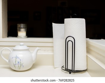 A Simple Paper Towel Holder, Holding A White Paper Towel Roll On A Kitchen Counter.