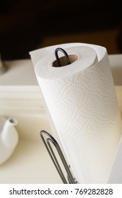 A Simple Paper Towel Holder, Holding A White Paper Towel Roll On A Kitchen Counter.