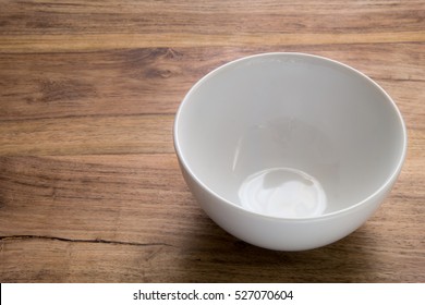 A Simple Picture Of An Empty White Bowl On A Rustic Wooden Table Bathed In Natural Light. Uncluttered. Space To The Side Of The Vessel For Text (if Required). 