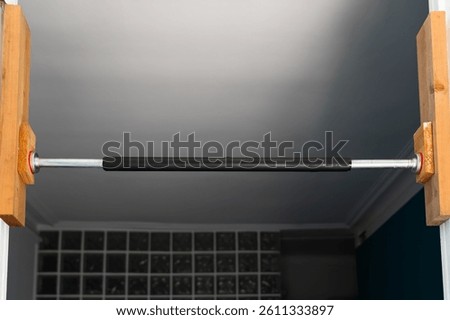 Simple pull-up bar, securely installed in a doorway for home strength training and fitness.