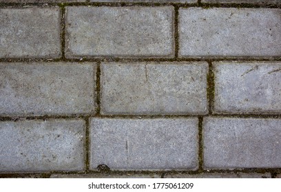 Simple rectangular paving slabs. Gray paving tiles details close-up. The texture of paving tiles, the pattern on the tile. Concrete paving slab flagstone. Sidewalk pavement pattern.
