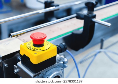 Simple red emergency stop button, Conveyor belt with empty cans. Production and preparation of conveyor equipment in the production of machines