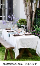 Simple Rustic Country Style Table Setting For A Party Gathering In A Casual Outdoor Garden Setting