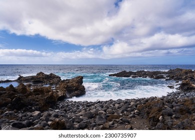 A simple seascape with a rocky shore and azure water