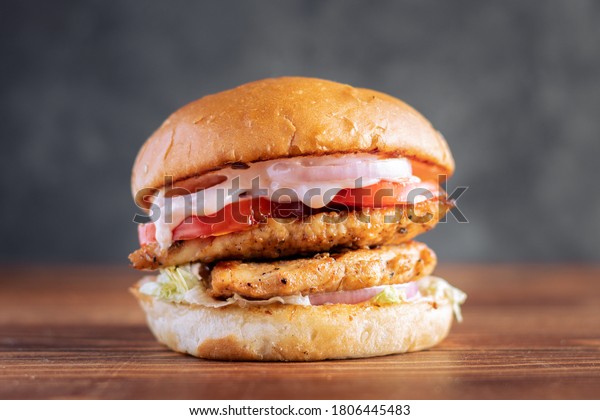 Simple shot of a Double Patty Chicken Burger\
on a dark background\
