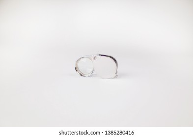 A Simple Silver Jeweler's Loupe On A White Background