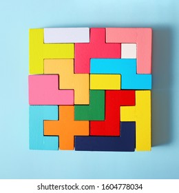 Simple Solutions To Decide Problems. Strategy In Business. Wooden Tetris Cubes On A Blue Background As A Puzzle Symbol. The Challenge With A Difficult Solution