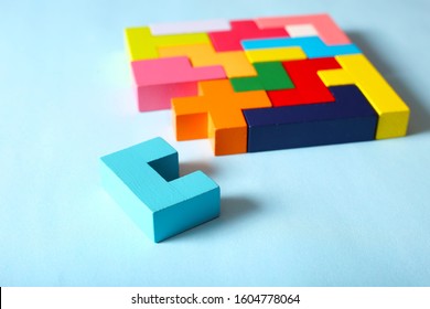 Simple Solutions To Solve Problems. Strategy In Business. Wooden Tetris Cubes On A Blue Background As A Puzzle Symbol. The Challenge With A Difficult Solution