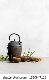 Simple Still Life With Tea Set, Scattered Tea, Bamboo Mat, Sticks, Incense. Asian Background With Space For Text.