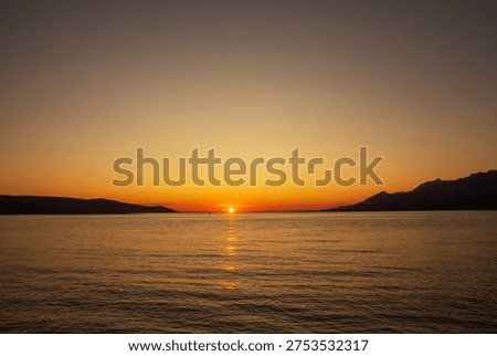 Simple summer sunset  in Rovanjska, small place at Croatian coast in golden orange colors reflecting in a calm and quiet sea surface, with clear sky  suitable to write down some gratitude notes or thoughts at the end of the day