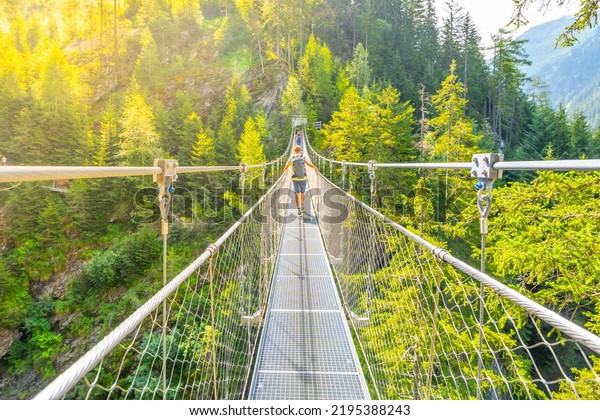 Simple\
suspension footbridge over mountain\
valley