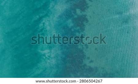 Simple top-down aerial view of clear turquoise ocean water in Thailand, showing natural gradients, surface texture, and abstract patterns. Minimal seascape suitable for travel, nature, and background design use.