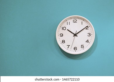 Simple Wall Clock Hanging On A Blue Wall