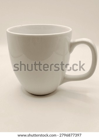 A simple white ceramic mug with a smooth glossy finish and classic curved handle is displayed against a clean background, highlighting its timeless design and everyday elegance.
