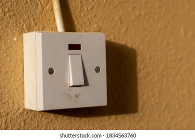 A Simple White Electrical Light Switch On A Brown Wall Outdoors In Sunshine. Industrial, Residential Or DIY Construction Concepts.