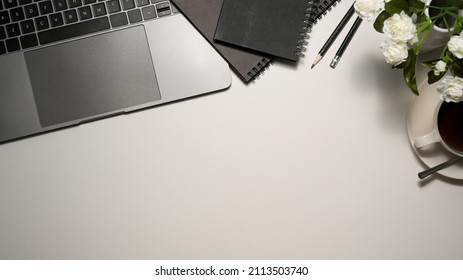 Simple white working table with office supplies, laptop computer, notebook, pencils, accessories and copy space. top view