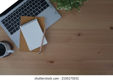 Simple workplace with computer laptop, notebook, potted plant and coffee cup. Flat lay.