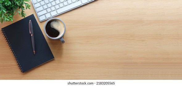 Simple workplace with wireless keyboard, notebook and coffee cup on wooden table. Top view with copy space for your text. - Powered by Shutterstock
