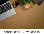 Simple workspace with cup of coffee, book and potted plant on brown background. Top view, flat lay.