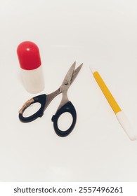 A simple yet functional composition featuring a pair of scissors, a roll of twine, and a marker pen, arranged on a clean white background.