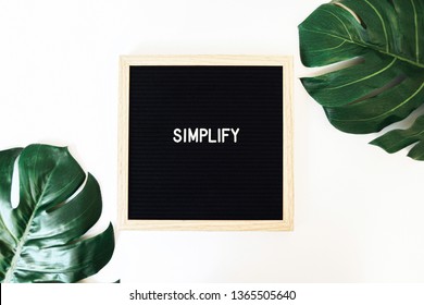 Simplify Letter Board & Monstera is a styled stock photo featuring two tropical (Monstera) leaves and a classic felt letter board with one simple word: SIMPLIFY. 