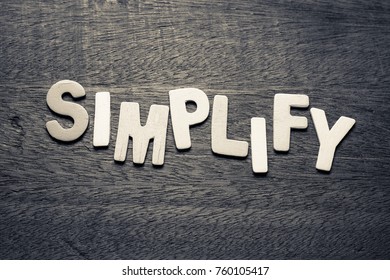 Simplify Word  By Wood Letters On Wood Background