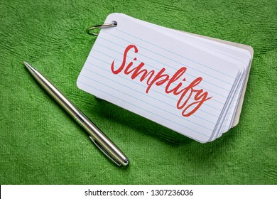 Simplify Word - Handwriting On An Index Card With A Pen Against Green Textured Paper