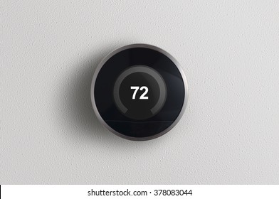 A Simplistic Photo Of A Round, Modern, Programmable Digital Thermostat, On A Clean White Wall.