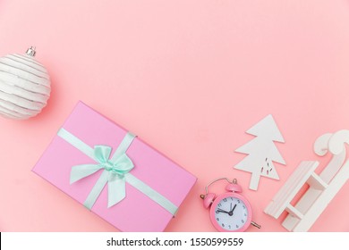 Simply minimal composition winter objects ornament sled fir tree ball gift box isolated pink pastel background. Christmas New Year december time for celebration concept. Flat lay top view copy space