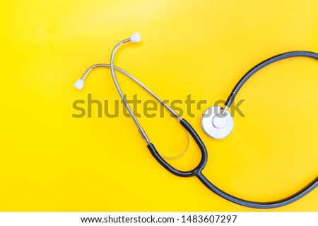 Simply minimal design with medicine equipment stethoscope or phonendoscope isolated on trendy yellow background. Instrument device for doctor. Health care life insurance concept