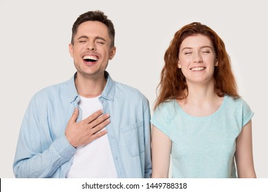 Sincere Young Family Couple Laughing Portrait, Handsome Man And Attractive Woman Laughing At Joke, Having Fun Together, Happy To Hear Perfect News, Isolated On Grey White Studio Background.