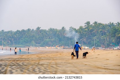 Sindhudurg, India - December  20, 2021 : Unidentified Dog Walker With Two Dogs Talking A Morning Walk At Beach Side