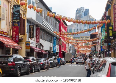 Singapore, Singapore - 01 05 2019: A View Down A Busy Street In The Chinatown District In Singapore Where Shoppers Can Be Seen And Overhead Red Lanterns.