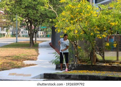 SINGAPORE- 1 MAR 2021: A Foreign Domestic Worker (FDW) Sweeps The Pavement Outside A House. A FDW Does House Work, Cooks, Cares For Elderly, Infirmed Or Disabled, Kids, Washes Car And Goes Marketing.