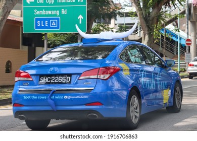 SINGAPORE – 11 FEB 2021: Taxi Top Displays A Big Pair Of Ox's Horns, The Boot Has A Tail And The Car Side Displays A Cow's Drawing Are Sure To Grab Attention For The MOOVE MEDIA Advertising Company. 