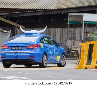 SINGAPORE – 11 MAR 2021: Taxi Top Displays A Big Pair Of Ox's Horns, The Boot Has A Tail And The Car Side Displays A Cow's Drawing Are Sure To Grab Attention For The MOOVE MEDIA Advertising Company. 