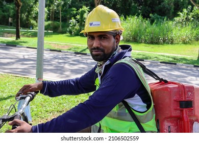 SINGAPORE - 14 JAN 2022: A Migrant Worker From Chennai, India Cycles To His Yio Chu Kang Crescent  Construction Site To Start Work At 9 AM. He Takes Off His Face Mask For Photography. 