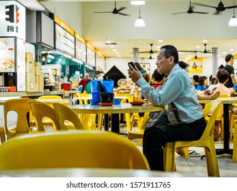 SINGAPORE - 17 MAR 2019 - A Middle Aged Asian Chinese Singaporean Man In Office Attire Enjoys A Late Night Beer At An Eatery / Coffeeshop / Kopitiam, / Hawker Centre 