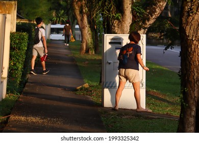 SINGAPORE - 18 JUN 2021. A Lady Posts A Letter Into The Singpost Letter Box At Lentor Estate. 300 Million Mail Articles A Day Are Collected. There Are Around 800 Letter Boxes.