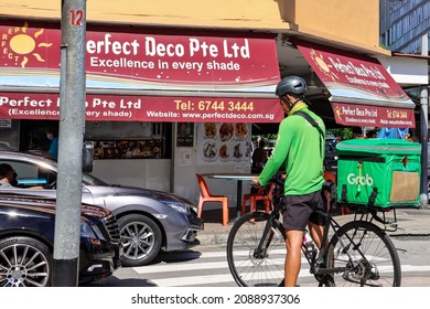 SINGAPORE - 2 DEC 2021: A GrabFood delivery rider. Online platforms dangle incentives to make him work long hours and operate faster to complete deliveries. His health and safety may be compromised. 