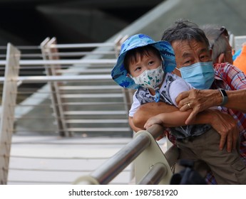 SINGAPORE -2  JUN 2021: Grandson Bonds In An Outing With Grandpa At The Esplanade Theatres Amid Covid-19 Curbs. Both Wear Their Disposable Face Masks Properly - Covering Nose And Chin.