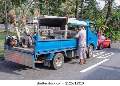 SINGAPORE - 20 FEB 2022: A Sunburnt 73-year-old Landscape Contractor With Over 50 Years Of Experience Maintains The Garden Of A Private House In Lentor Estate. Two Migrant Workers Help Him. 