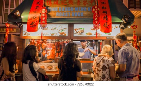 Singapore, 20 September 2017: Image Of Crowded People In Front Of Traditional Noodle Shop In Chinatown, Singapore. Traditional Chinese Street, Market, Road With Shop-houses.