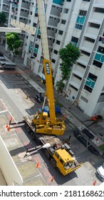 Singapore, 21 July 2022. Lorry Crane Lifting Pipes Between Public Housing In Singapore.