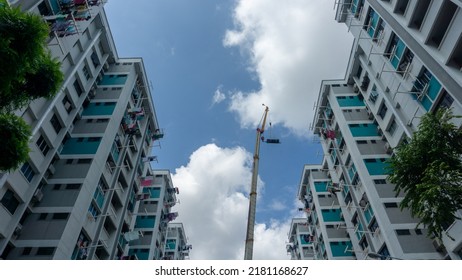 Singapore, 21 July 2022. Lorry Crane Lifting Pipes Between Public Housing In Singapore.