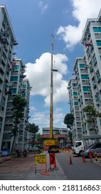 Singapore, 21 July 2022. Lorry Crane Lifting Pipes Between Public Housing In Singapore.