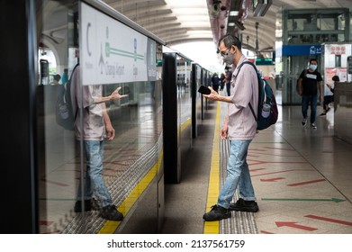 Singapore - 21st March 2022: An Elderly Man Is Checking His Phone While Waiting For The Train.