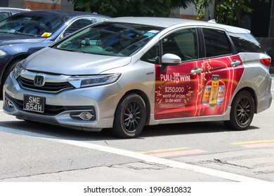 SINGAPORE - 25 JUN 2021. A Private Car Displays Side Advertisements For A Corporation. Automobile Adverts Generate Income To Help Offset The High Maintenance Costs Of Car Ownership Here.