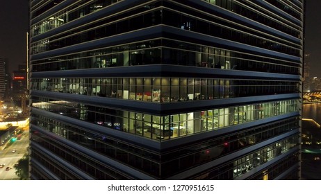 Singapore - 25 September 2018: Close Up For Exterior Of Modern Office Building Corner With Lighted Windows And People Inside. Shot. Aerial Of The Downtown Office Building Corner At Night, Lighted