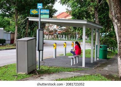 SINGAPORE - 26 NOV 2021: A Migrant Domestic Worker Waits For The Shuttle Bus No. 825 At Lentor Loop Bus Stop.